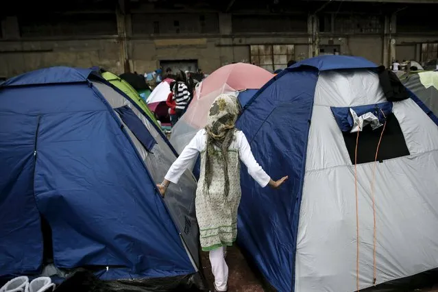 A girl walks among tents at a makeshift camp for refugees and migrants at the port of Piraeus, near Athens, Greece March 24, 2016. (Photo by Alkis Konstantinidis/Reuters)