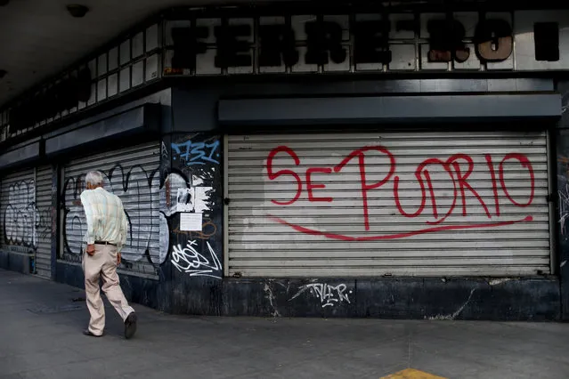 The Spanish words “It rotted” covers a closed shop in Caracas, Venezuela, Monday, March 18, 2019. Many storefronts in Caracas are graffiti-scrawled security doors chained shut. (Photo by Natacha Pisarenko/AP Photo)