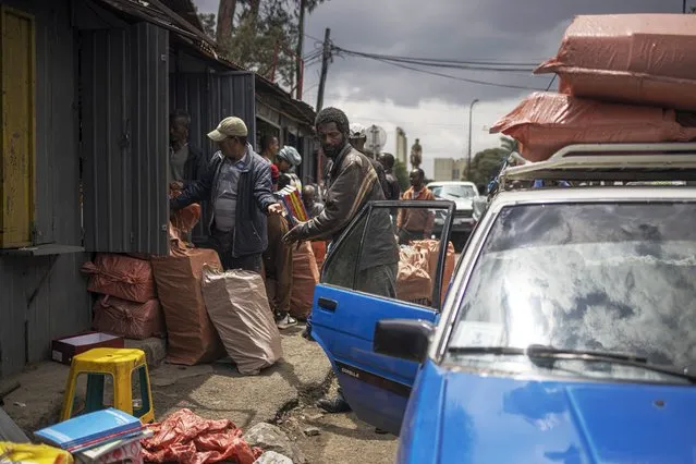 People clear out street stalls before a planned demolition in the historical Piazza neighbourhood of Addis Ababa on March 11, 2024. (Photo by Michele Spatari/AFP Photo)