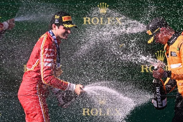 (L-R) Winner Ferrari's Spanish driver Carlos Sainz Jr and third-place McLaren's British driver Lando Norris celebrate on the podium after the Australian Formula One Grand Prix at Albert Park Circuit in Melbourne on March 24, 2024. (Photo by William West/AFP Photo)