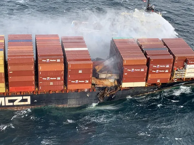 Tugboats pour water on the container ship Zim Kingston after it caught fire the day before off the coast of Victoria, British Columbia, Canada on October 24, 2021. (Photo by Canadian Coast Guard/Handout via Reuters)