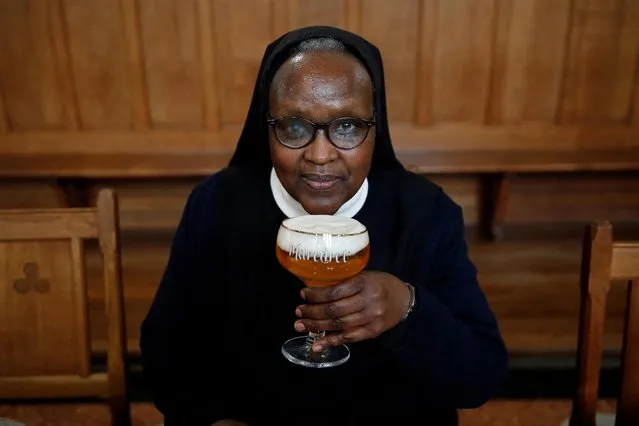 Benedictine Sister Gertrude drinks a “Maredret” beer during an interview with Reuters at the Maredret Abbey, which signed a partnership with the Anthony Martin brewing group to produce two beers labeled “Maredret”, with ingredients inspired by the monastery garden, in Anhee, Belgium, December 8, 2021. (Photo by Johanna Geron/Reuters)