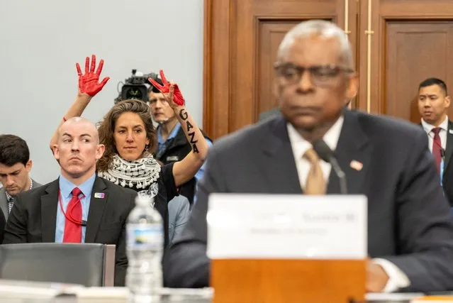 Protesters from the group Code Pink gesture as U.S. Defense Secretary Lloyd Austin and the Chairman of the Joint Chiefs of Staff General Charles Brown, Jr. testify before a House Appropriations Defense Subcommittee hearing on U.S. President Biden's proposed budget request for the Department of Defense on Capitol Hill in Washington on April 17, 2024. (Photo by Ken Cedeno./Reuters)