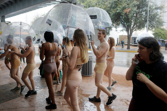 Onlookers watch people stripped of their clothes to promote the new Bravo series “Stripped” during at the South by Southwest (SXSW) Music Film Interactive Festival 2017 in Austin, Texas, U.S., March 11, 2017. (Photo by Brian Snyder/Reuters)