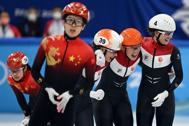 Netherlands' Suzanne Schulting (2R) celebrates with Netherlands' Yara van Kerkhof (3L) and Netherlands' Selma Poutsma after a semi-final heat of the women's 3000m relay short track speed skating event during the Beijing 2022 Winter Olympic Games at the Capital Indoor Stadium in Beijing on February 9, 2022. (Photo by Manan Vatsyayana/AFP Photo)