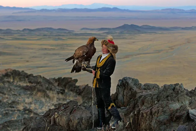 13 year old Ashol Pan with her eagle – Despite her young age, Ashol had the amazing ability to control and be able to caress her eagle, almost as if she had been with it for years. (Photo by Asher Svidensky/Caters News)