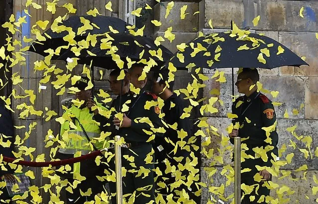 Paper yellow butterflies are thrown in the air at the entrance of the cathedral during a ceremony to honor late Nobel Prize laureate in Literature Gabriel Garcia Marquez in Bogota, on April 22, 2014. Colombia bids farewell Tuesday to its favorite son, Garcia Marquez, with a national tribute filled with the late Nobel winner's favorite music and roses. Garcia Marquez died in Mexico City on Thursday at age 87. (Photo by Luis Acosta/AFP Photo)