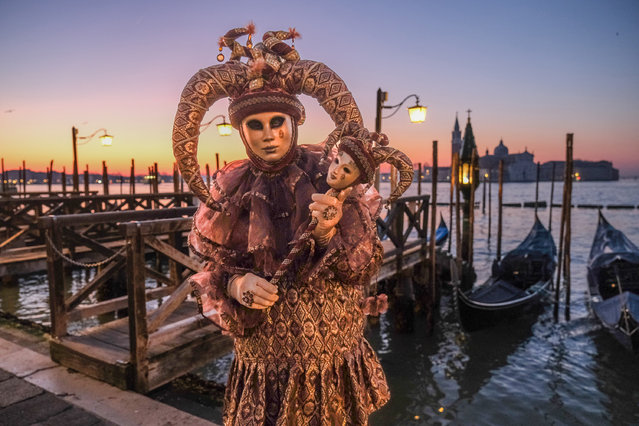 A masked reveler poses for a sunrise portrait in St. Mark's Square on February 10, 2023 in Venice, Italy. The Venice Carnival will begin on February 4 and end on February 21, 2023 and will be titled “Take Your Time for the Original Signs”. (Photo by Stefano Mazzola/Getty Images)