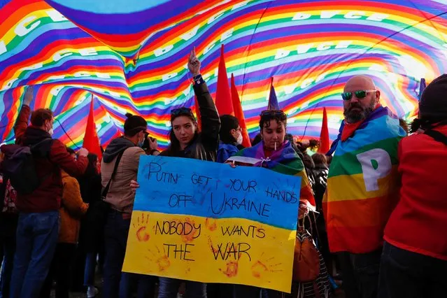 People stand under a huge rainbow banner during a protest against Russia's invasion of Ukraine, at San Giovanni square, in Rome, Italy, March 5, 2022. (Photo by Remo Casilli/Reuters)