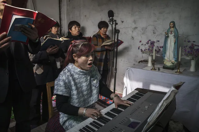 A Chinese Catholic woman plays a keyboard as she sings hymns at the Palm Sunday Mass during the Easter Holy Week at an “underground” or “unofficial” church on April 9, 2017 near Shijiazhuang, Hebei Province, China. China, an officially atheist country, places a number of restrictions on Christians, allowing legal practice of the faith only at state-approved churches. The policy has driven an increasing number of Christians and Christian converts 'underground' to secret congregations in private homes and other venues. While the size of the religious community is difficult to measure, studies estimate more than 80 million Christians inside China; some studies support the possibility it could become the most Christian nation in the world in the coming years. Officially there have been no relations between China and the Vatican since the country's modern founding in 1949 though in recent years there have been signs of warming relations between Chinese president Xi Jinping and Pope Francis that could possibly allow greater religious freedom in the future. At present, the split means approved Chinese Christians worship within a state-sanctioned Church known as the Patriotic Association which regards the Communist Party as its leader, not the Pope in Rome. (Photo by Kevin Frayer/Getty Images)