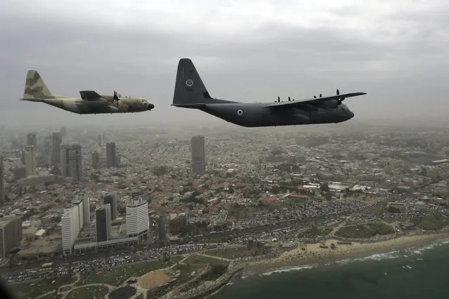 Israeli Air Force military cargo airplane C-130J Super Hercules, right, and Hercules C-130, left, fly over the city of Tel Aviv during an air show celebrating Independence Day Tuesday, May 6, 2014. Israel is celebrating its annual Independence Day, marking 66 years since the founding of the state in 1948. (Photo by Tsafrir Abayov/AP Photo)