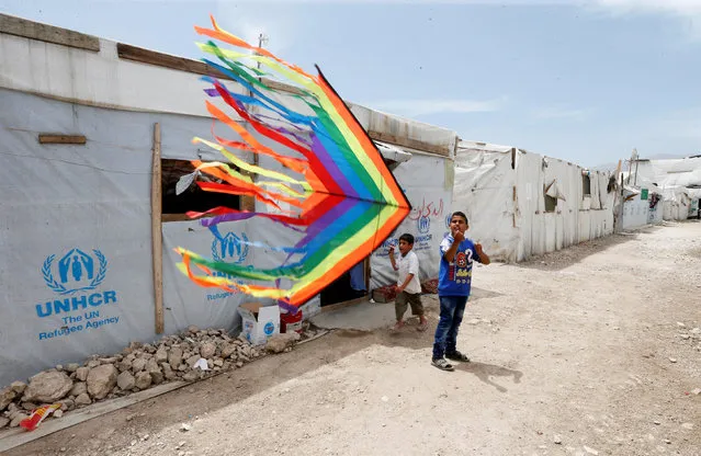 Syrian refugee boys fly a kite inside a Syrian refugee camp in Bekaa valley, Lebanon May 17, 2016. (Photo by Mohamed Azakir/Reuters)