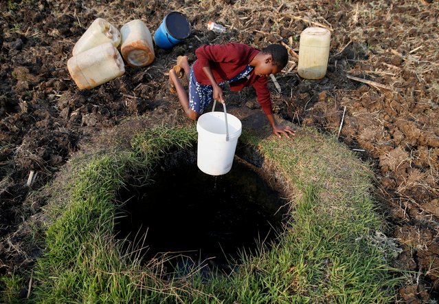 A woman fetches water from a well in Warren Park suburb, Harare, Zimbabwe, September 24, 2019. (Photo by Philimon Bulawayo/Reuters)