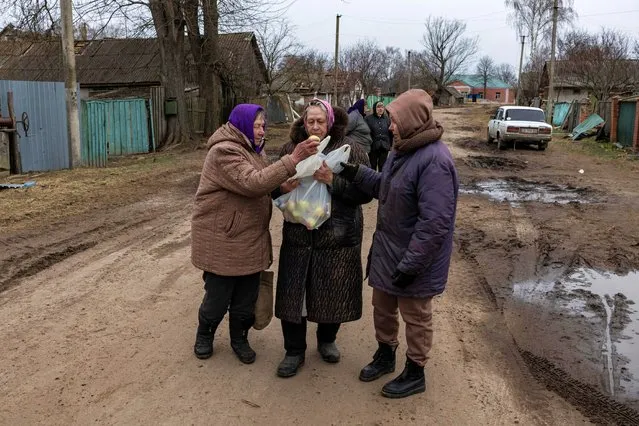 Women walk after receiving humanitarian aid, as Russia's invasion of Ukraine continues, in the village of Sloboda, outside Chernihiv, Ukraine on April 5, 2022. (Photo by Marko Djurica/Reuters)