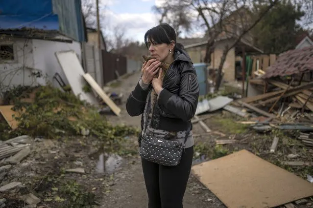 Ira Gavriluk holds her cat outside her house, where his husband and brother were killed, in Bucha, on the outskirts of Kyiv, Ukraine, Monday, April 4, 2022. Russia is facing a fresh wave of condemnation after evidence emerged of what appeared to be deliberate killings of civilians in Ukraine. (Photo by Rodrigo Abd/AP Photo)