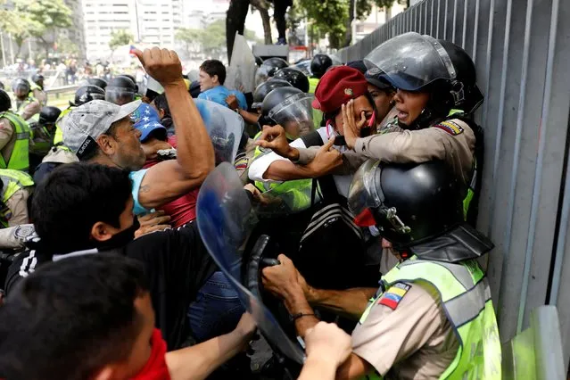 Demonstrators scuffle with security forces during an opposition rally in Caracas, Venezuela, April 4, 2017. (Photo by Carlos Garcia Rawlins/Reuters)