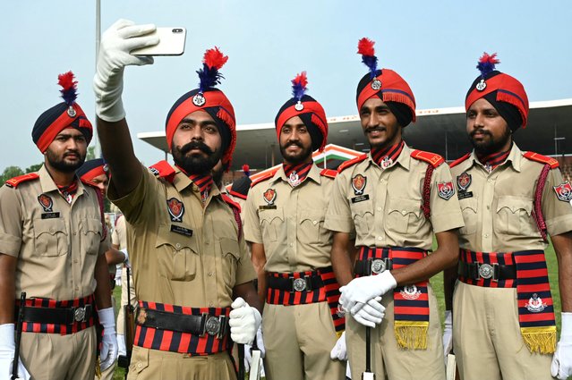 Police personnel pose for a selfie before the full dress rehearsal for the upcoming India's Independence Day celebrations in Amritsar on August 13, 2024. (Photo by Narinder Nanu/AFP Photo)