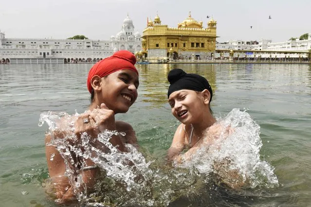 Sikh devotees take a bath in the sacred pond on the occasion of “Baisakhi”, a spring harvest festival for Sikhs and Hindus, at the Golden Temple in Amritsar on April 14, 2022. (Photo by Narinder Nanu/AFP Photo)