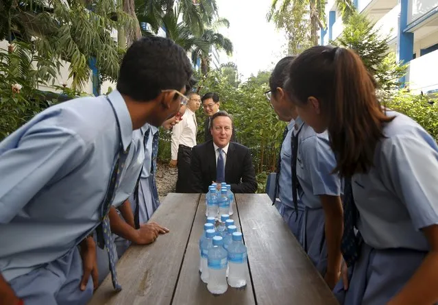 Britain's Prime Minister David Cameron takes his seat as he mingles with students during a visit to Commonwealth Secondary School in Singapore July 29, 2015. (Photo by Edgar Su/Reuters)