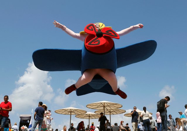 An Israeli dressed as an aeroplane is pictured on the beach in the Mediterranean coastal city of Tel Aviv on May 5, 2022, as Israel marks Independence Day (Yom HaAtzmaut), 74 years since the establishment of the Jewish state. Israel's first prime minister David Ben-Gurion declared the existence of the State of Israel in Tel Aviv in 1948, ending the British mandate. (Photo by Jack Guez/AFP Photo)