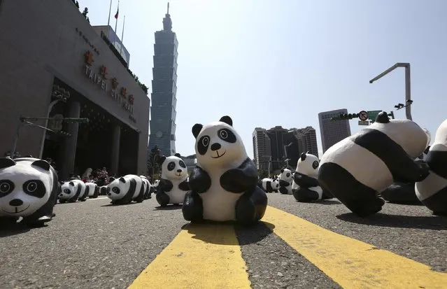 Papier mache pandas, created by French artist Paulo Grangeon, are seen displayed outside Taipei City Hall as part of an exhibition called “Pandas on Tour”, February 28, 2014. According to local media, the event was launched by the World Wildlife Fund (WWF) first in Paris in 2008. Approximately 1,600 panda sculptures were displayed in the exhibition to remind people of the similar number of giant pandas still living in the wild and call on people's protection of endangered species. (Photo by Patrick Lin/Reuters)