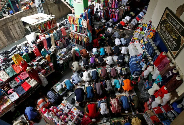Muslim labourers and shop keepers attend Friday prayers on a street next to Tanah Abang Textile Market in Jakarta, Indonesia June 2, 2017. (Photo by Darren Whiteside/Reuters)