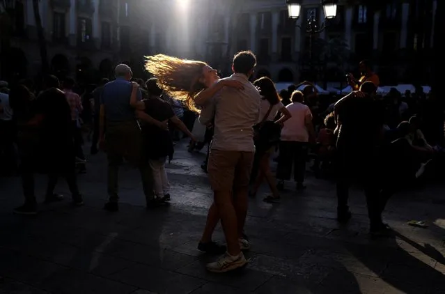 Tourists dance at Plaza Reial (Reial Square), after most pandemic-related restrictions were lifted in Barcelona, Spain, May 14, 2022. (Photo by Nacho Doce/Reuters)