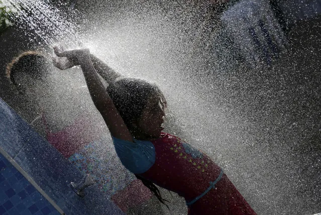 A holiday-maker takes a shower at a beach in Suez, 127 kilometers (79 miles) east of Cairo, Egypt, Sunday, August 9, 2015. Sunday’s temperature reached 39 °C (102 F) in Cairo and 45 °C in the Upper Egypt governorates. (Photo by Amr Nabil/AP Photo)