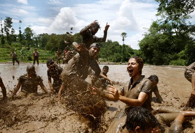 Students of Himalayan Agriculture College play in the mud while celebrating Asar Pandra festival in Lalitpur, Nepal, June 29, 2016. (Photo by Navesh Chitrakar/Reuters)