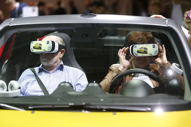 People use virtual reality goggles while sitting in a “smart fortwo cabrio” car prior to the Daimler annual shareholder meeting in Berlin, Germany, April 6, 2016. (Photo by Hannibal Hanschke/Reuters)