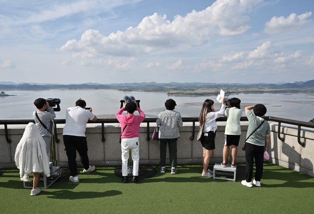 Visitors use binoculars to look at the North Korean side of the Demilitarised Zone (DMZ) dividing the two Koreas, from South Korea's Odusan Unification Observatory in Paju on October 9, 2024. North Korea's army said on October 9 it was moving to “permanently shut off and block the southern border” with Seoul and had informed the US military to prevent an accidental clash. (Photo by Jung Yeon-je/AFP Photo)