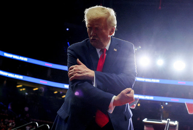 Donald Trump flexes his muscles during a campaign rally at PPG Paints Arena in Pittsburgh, Pennsylvania on November 4, 2024. (Photo by Brian Snyder/Reuters)