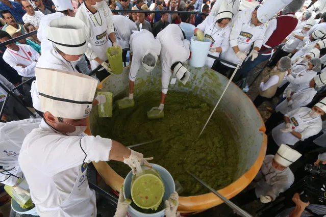 Volunteers from a culinary school mix mashed avocados as they attempt to set a new Guinness World Record for the largest serving of guacamole in Concepcion de Buenos Aires, Jalisco, Mexico September 3, 2017. (Photo by Fernando Carranza/Reuters)