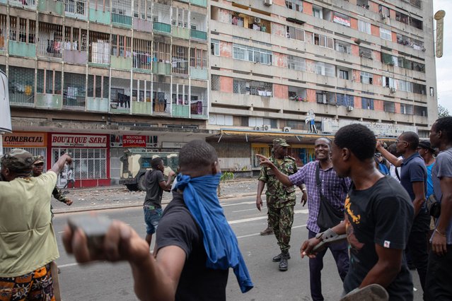 A protester aims a rock at a Mozambique soldier as he attempts to disperse protesters as they clash with Mozambican riot police in Maputo on November 27, 2024. Fresh anti-government protests erupted in Mozambique on November 27, 2024 after a police vehicle mowed down a woman at a demonstration in the capital for the opposition leader disputing October elections in a deadly weeks-long standoff AFP reporters at the scene said protestors hurled stones at security forces who fired bullets and tear gas as clashes broke out after the woman was struck while standing behind a large banner of opposition leader Venancio Mondlane. (Photo by Alfredo Zuniga/AFP Photo)