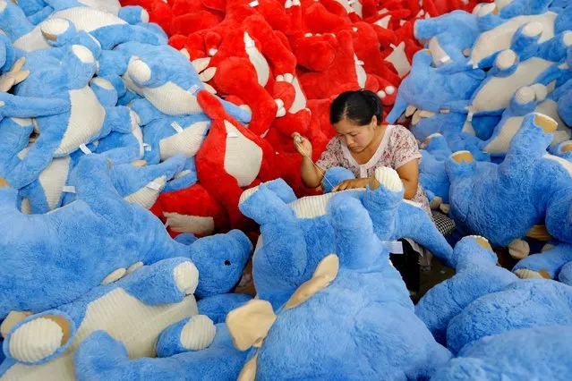 This photo taken on July 12, 2016 shows a worker in the process of making soft toys at a toy factory in Lianyungang, in eastern China's Jiangsu province. China's growth slipped to a new seven-year low of 6.6 percent in the second quarter, according to an AFP survey, despite government efforts to spur activity in the world's second-largest economy. (Photo by AFP Photo/Stringer)
