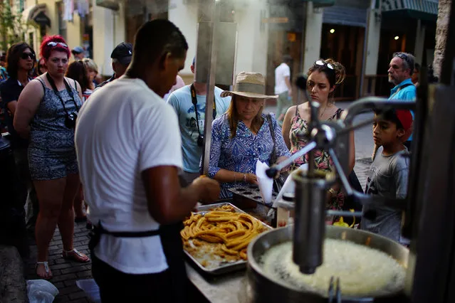 Tourists buy fried doughs in Havana, Cuba, January 17, 2017. (Photo by Alexandre Meneghini/Reuters)
