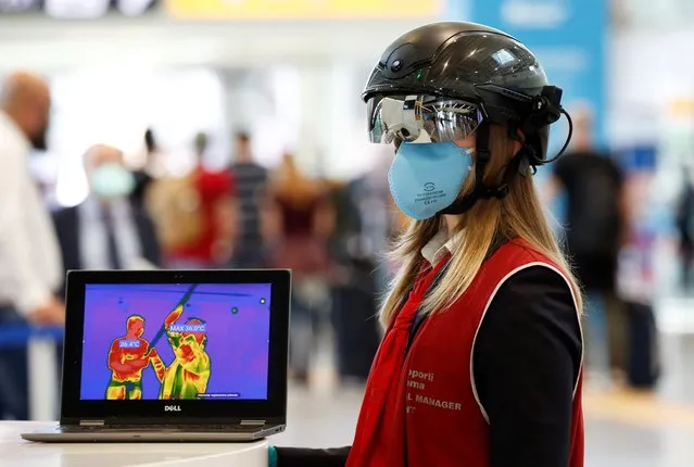 An airport official wears a “Smart Helmet”, a portable thermoscanner that can measure the temperature of passengers at a distance, at the Fiumicino airport, after Italy begun a gradual end to a nationwide lockdown due to the coronavirus disease (COVID-19), in Rome, Italy on May 6, 2020. (Photo by Remo Casilli/Reuters)