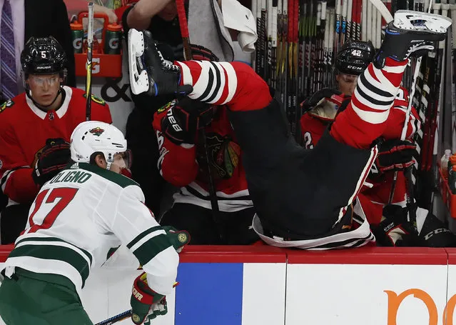Chicago Blackhawks' Brent Seabrook, right, goes over the boards after missing a check on Minnesota Wild's Marcus Foligno during the first period of an NHL hockey game Thursday, October 12, 2017, in Chicago. (Photo by Jim Young/AP Photo)