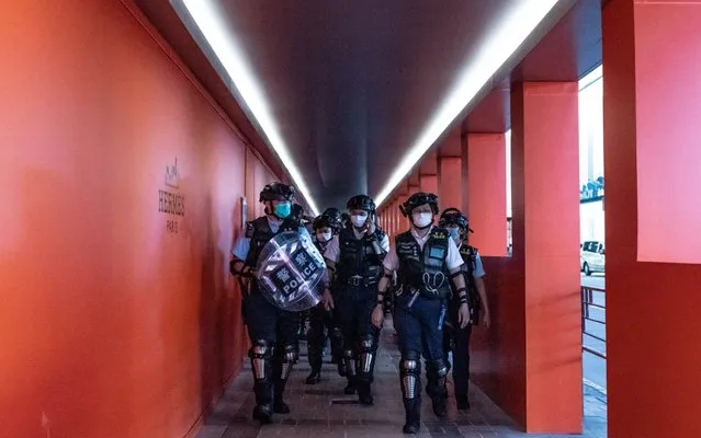 Riot police wearing protective masks patrol during a demonstration outside a shopping mall on May 10, 2020 in Hong Kong, China. Since the worst of the current coronavirus pandemic has passed, new anti-government protests have recently started to reappear in Hong Kong. (Photo by Anthony Kwan/Getty Images)