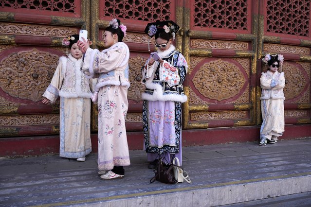 Visitors dressed in traditional costumes pose for photos at the Forbidden City in Beijing on Friday, February 21, 2025. (Photo by Ng Han Guan/AP Photo)