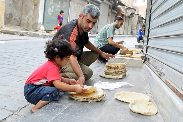 Residents spread pieces of bread out to cool them in Old Aleppo, Syria September 15, 2015. (Photo by Abdalrhman Ismail/Reuters)