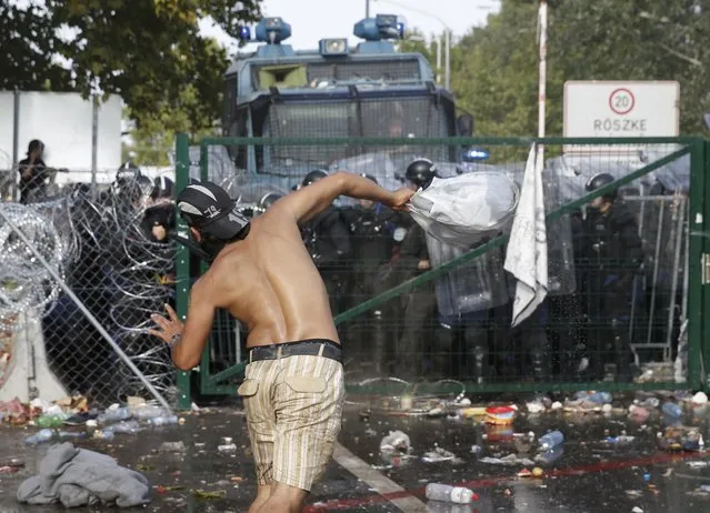 Migrants react on the Serbian side of the border as Hungarian riot police fires tear gas and water cannon near Roszke, Hungary September 16, 2015. (Photo by Marko Djurica/Reuters)