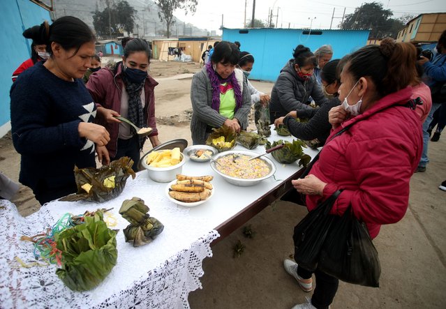 Women and men of the Shipibo Conibo ethnic group eat traditional Juanes during the celebration of San Juan, patron saint of the Peruvian Amazon in the Cantagallo neighborhood of Lima on June 24, 2020 in Lima, Peru. The community reopened 10 days ago after being isolated due to a massive number of positive cases of COVID-19 in mid May. (Photo by Raul Sifuentes/Getty Images)