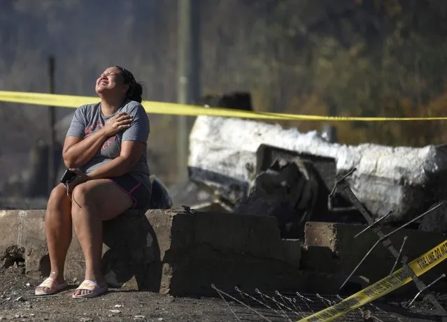 Jessica McCome cries while sitting near the remains of her home on Sunday, October 23, 2022 in Wooldridge, Mo. McCome, her husband Emmanuel, and children, Malachi, 13, Titus, 9 and Amira, 7, have lived in Wooldridge for 18 months. The fire destroyed most of the town. (Photo by Sam Koeppel/Missourian via AP Photo)