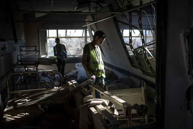 A volunteer looks for useful medical items inside the destroyed Salam Hospital on November 5, 2017 in Mosul, Iraq. Salam Hospital, Mosul's main hosptal was the scene of heavy fighting and was destroyed by coalition airstrikes, due to a sever shortage of medical equipment, staff from the hospital continue to scavenge through the rubble to find undamaged medical items to be used at the temporary hospital now setup across the street. (Photo by Chris McGrath/Getty Images)