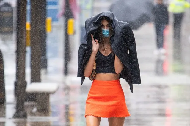 A shopper gets caught in a heavy downpour of rain on Oxford Street, London on June 27, 2020, as sunshine and showers are forecast for much of England and Wales on Saturday, with temperatures expected to hover around 22°C (71.6F). (Photo by Dominic Lipinski/PA Images via Getty Images)