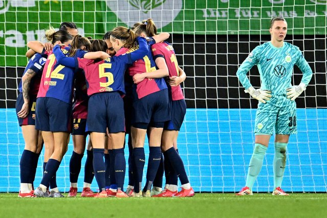Barcelona's players celebrate their side's third goal during the Women's Champions League, quarter-final first leg, soccer match between VfL Wolfsburg and FC Barcelona in Wolfsburg, Germany, Wednesday, March 19, 2025. (Photo by Swen Pfoertner/dpa via AP Photo)