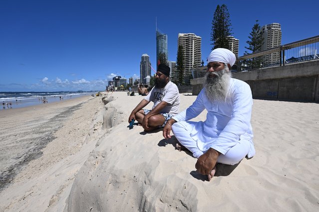 Tourists from India sit at the edge of a beach erosion escarpment at Surfers Paradise on the Gold Coast, Australia, 13 March 2025. As the recovery from ex-tropical cyclone Alfred's devastating impact ramps up, tourists are being urged to maintain their Easter holiday plans. (Photo by Dave Hunt/EPA)