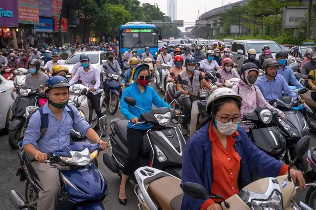 Motorbike riders with face masks are stuck in traffic during the morning peak hour on May 19, 2020 in Hanoi, Vietnam. Though some restrictions remain in place, Vietnam has lifted the ban on certain entertainment facilities and non-essential businesses, including pubs, cinemas and spas & other tourist attractions to recover domestic tourism. On April 23, the Ministry of Transport started to increase domestic flights and trains to major destinations with limited passenger capacity. As of May 19, Vietnam has confirmed 324 cases of coronavirus disease (COVID-19 ) with no deaths in the country, 263 fully recovered and no new case caused by community transmission for 33 days. (Photo by Linh Pham/Getty Images)