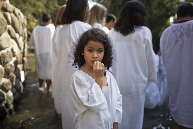 A Christian pilgrim girl from Brazil waits to be baptized in the water of the Jordan River during a ceremony at the Yardenit baptismal site near the northern Israeli city of Tiberias October 15, 2014. (Photo by Finbarr O'Reilly/Reuters)